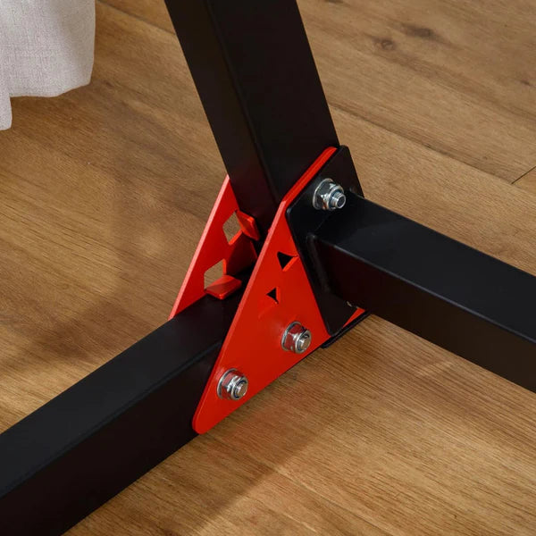 Close-up of a metal bracket with red on a wooden floor
