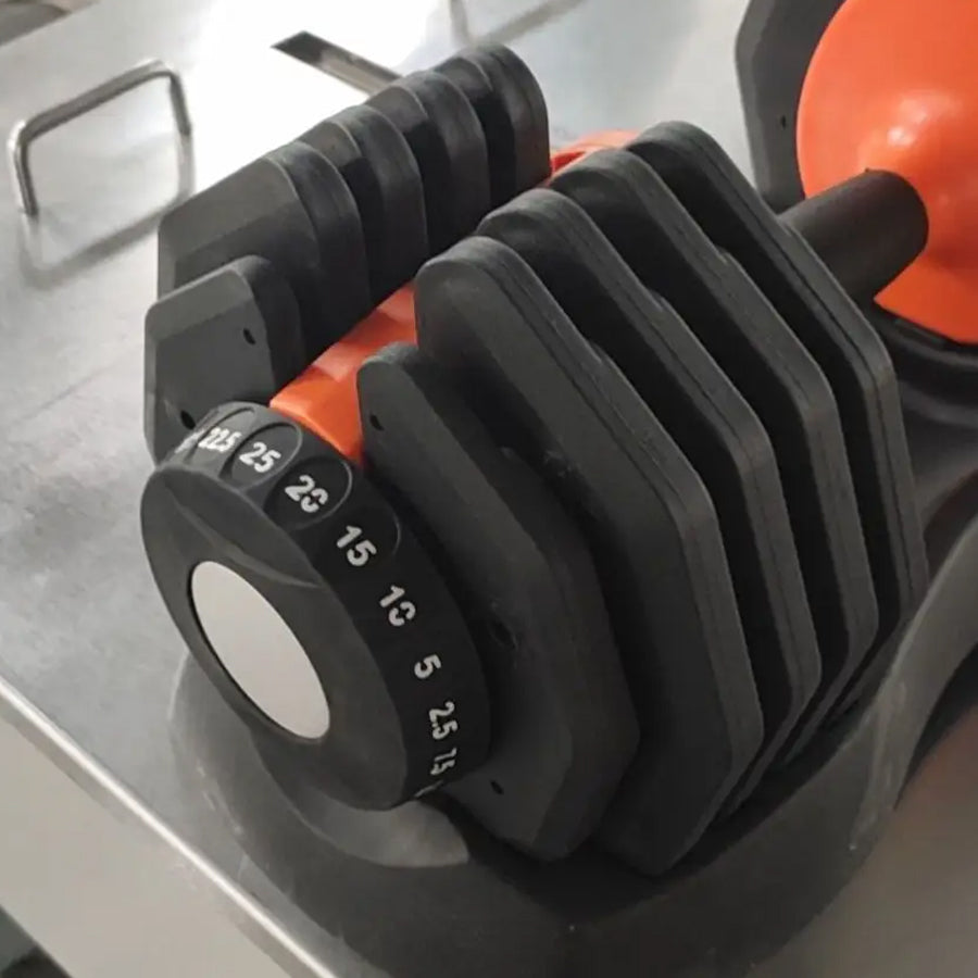 Set of adjustable dumbbells on a metallic surface