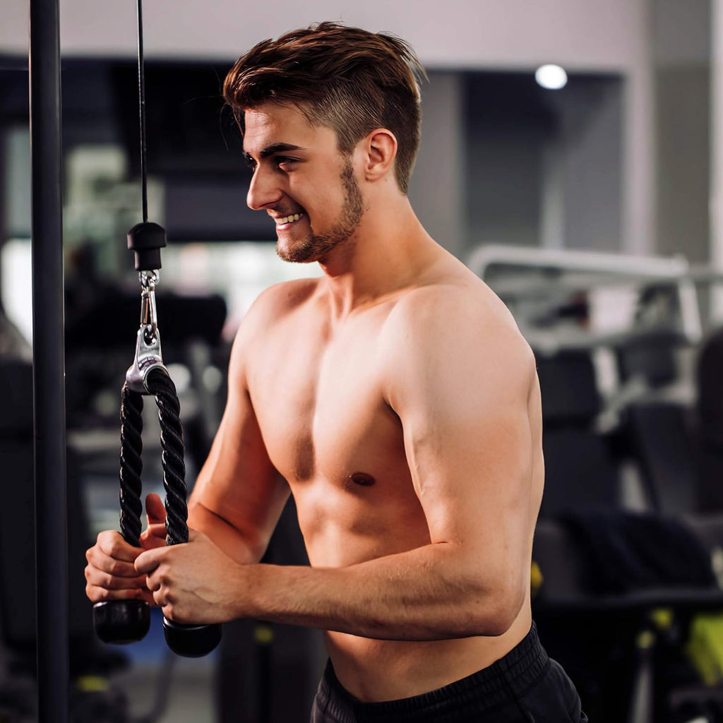 Man exercising with a rope pulley in a gym setting