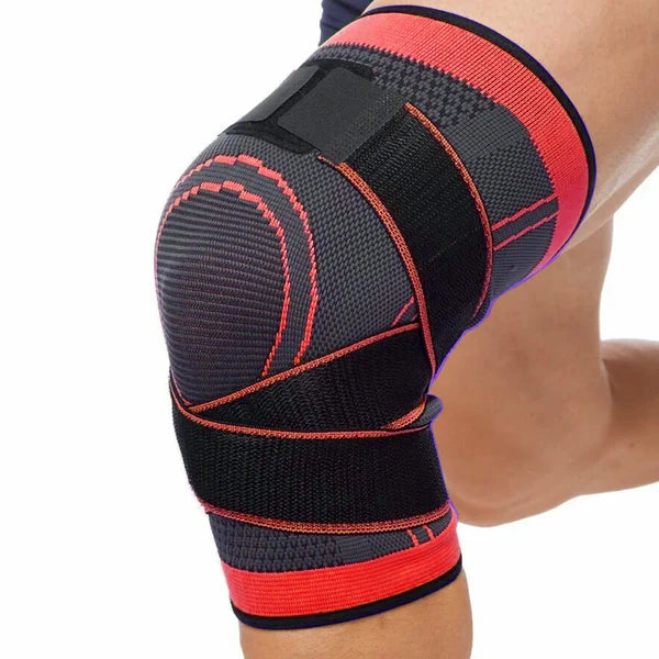 Black and red knee brace on a person's knee against a white background