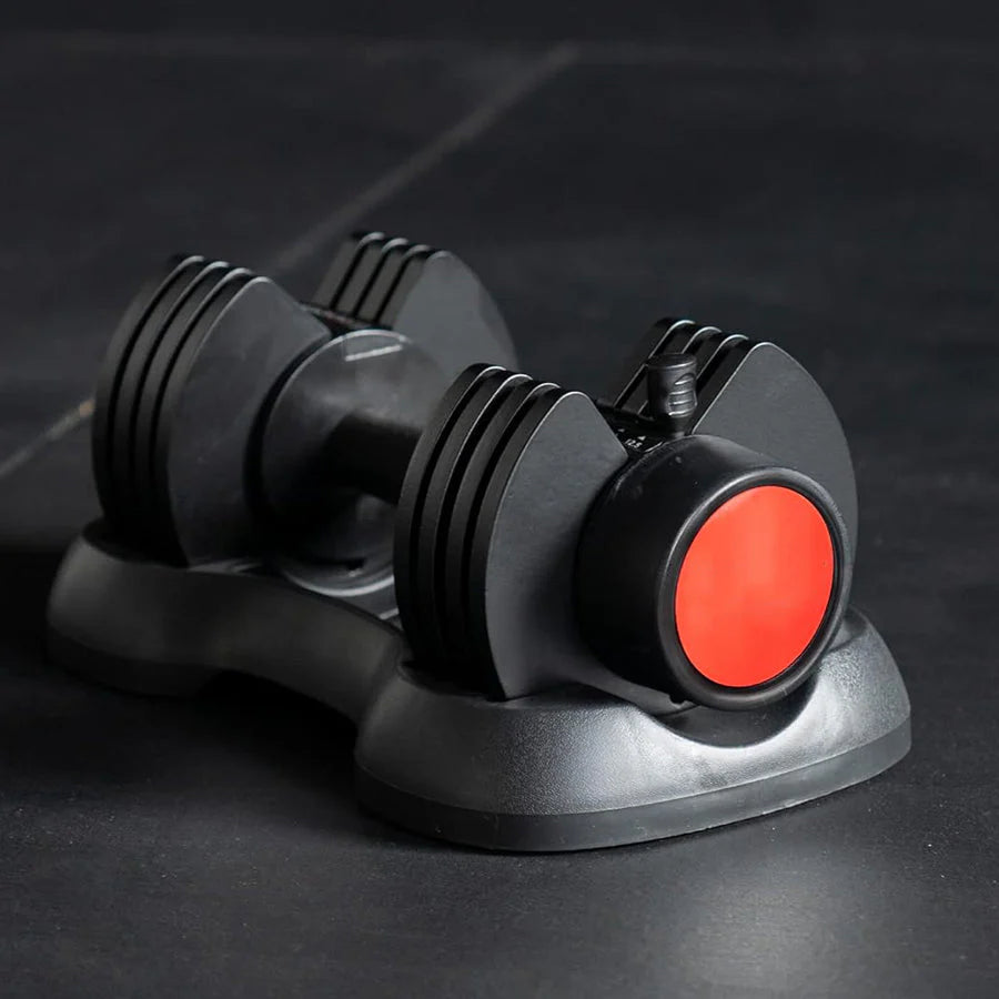 Black and red dumbbell weight trainer on a dark surface