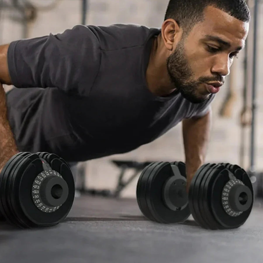 Man performing push-ups with adjustable dumbbells on a gym floor.