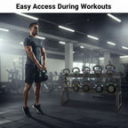 Man holding a kettlebell with a rack of kettlebells in a gym setting