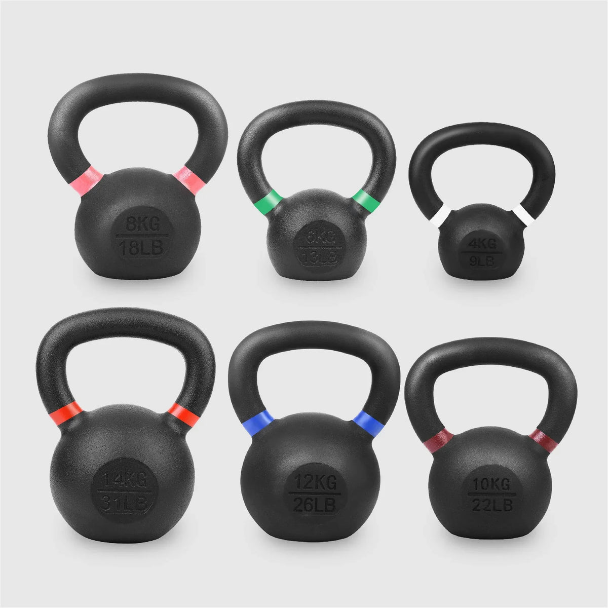 Set of six black kettlebells with color-coded weight markings on a light gray background