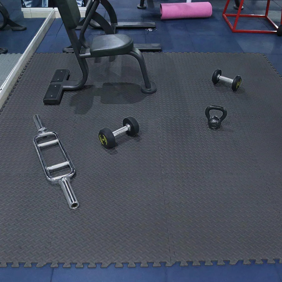 Gym equipment on a black mat with blue flooring