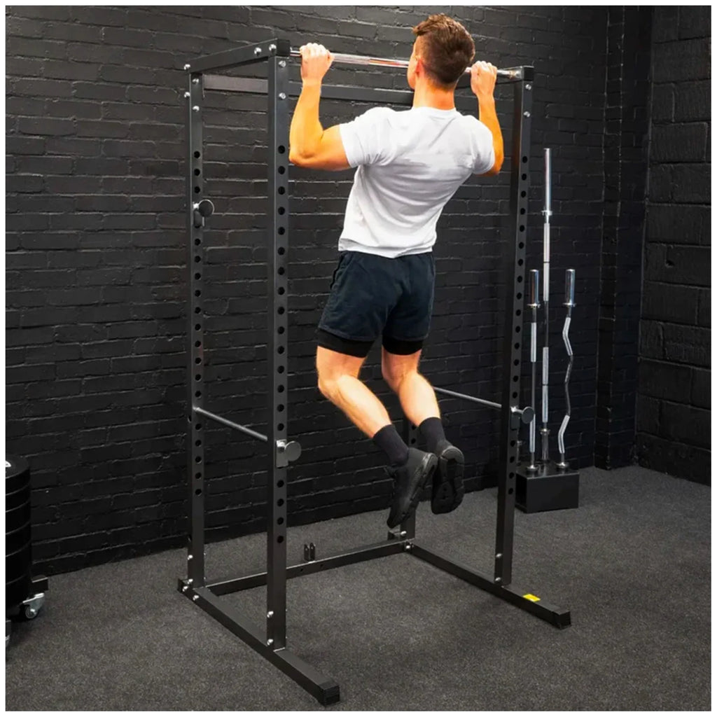 Person using a pull-up bar in a home gym setting.
