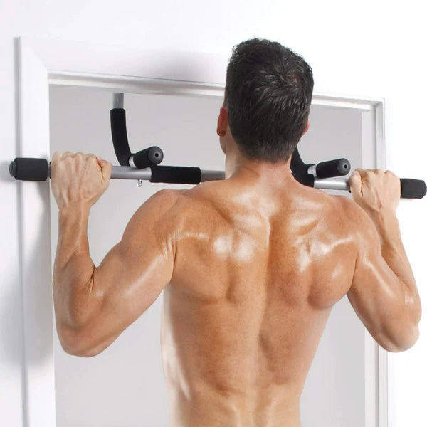 Man performing pull-ups on a door bar against a white background