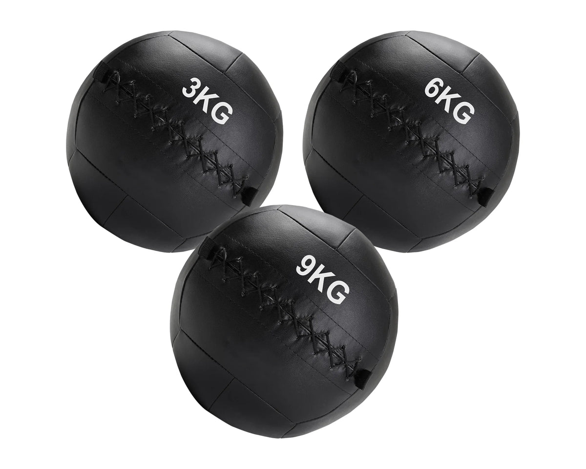 Three black weighted medicine balls with different weights on a white background