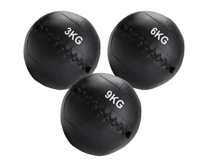 Three black weighted medicine balls with different weights on a white background