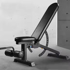 Black adjustable weight bench against a gray concrete wall.