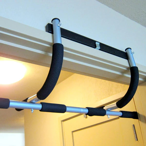 Pull-up bar attached to a door frame with a bright light source in the background.